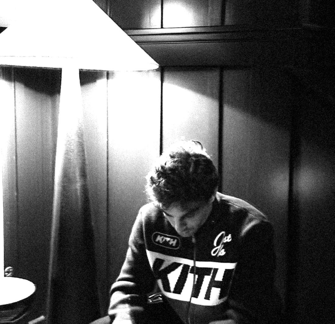 João Gerçossimo sentado sob a luz de um abajur, em preto e branco